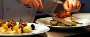 one of our chefs plating up dishes on the passe at Godswell Park Luxury Care Home